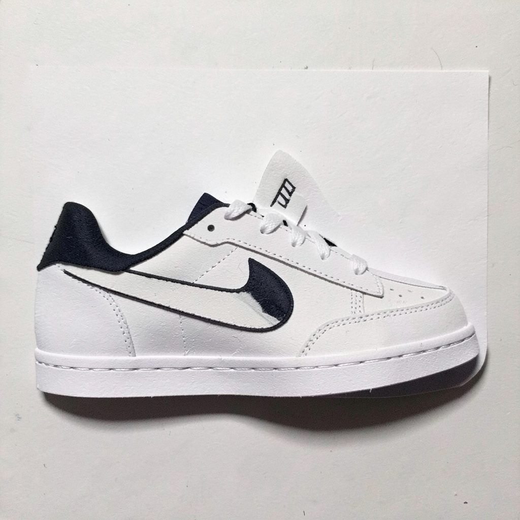 Layered paper cutout of a low profile sneaker in off white and sand tones