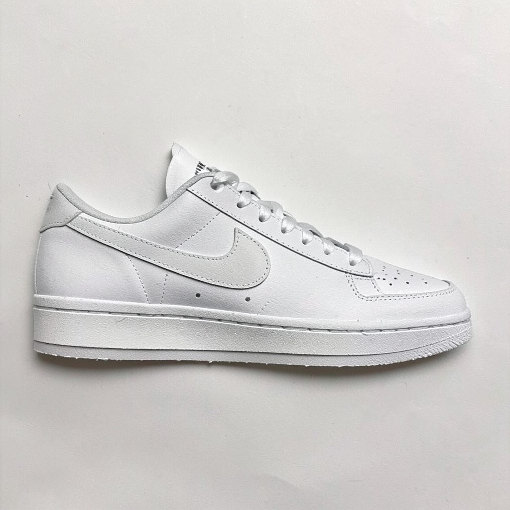 Layered paper cutout of a tennis sneaker silhouette in muted blues